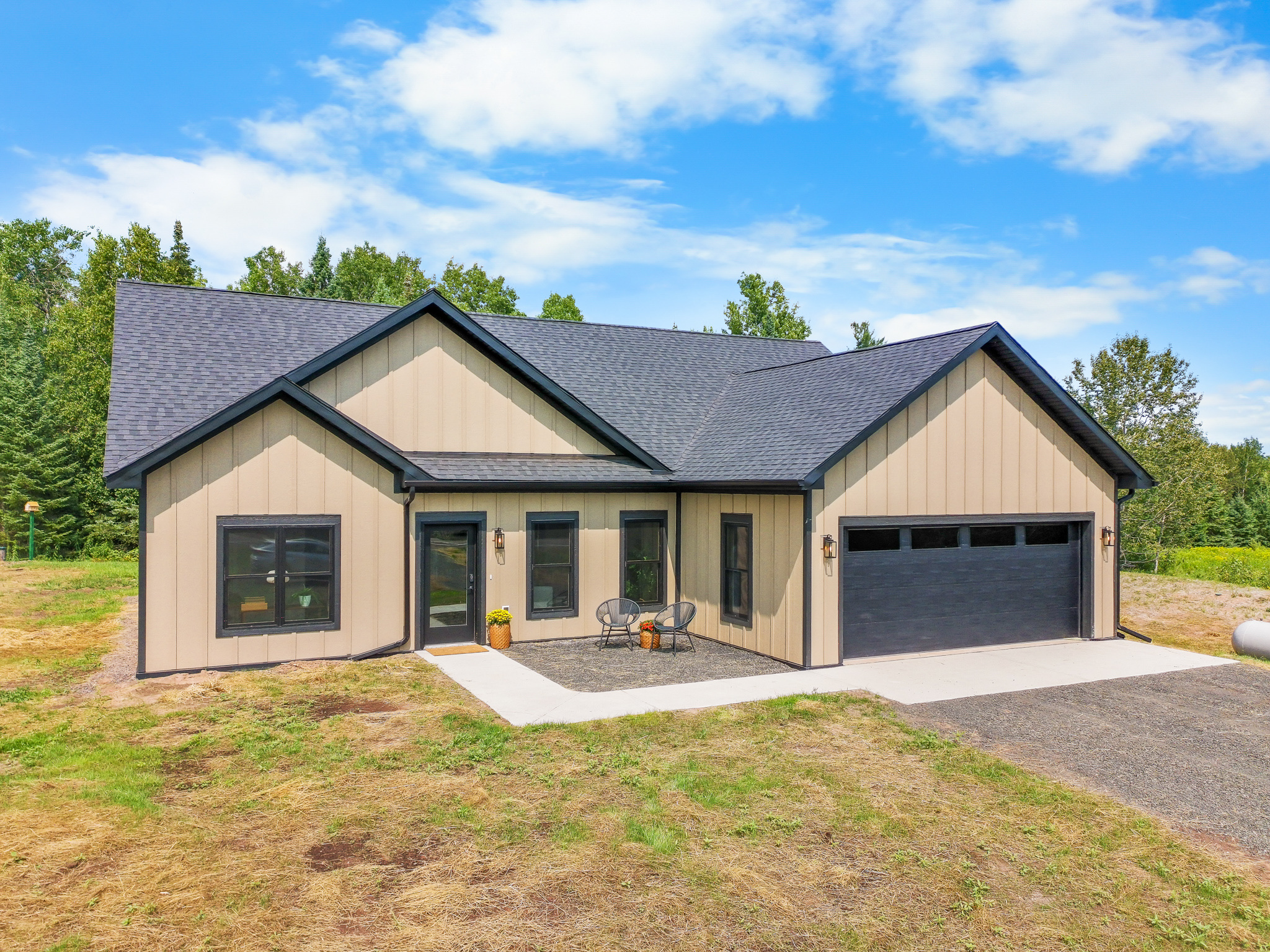 The Woodland — completed home in a warm tan palette with black trim